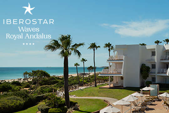 Hotelanlage in weiß mit Palmen und links das Meer